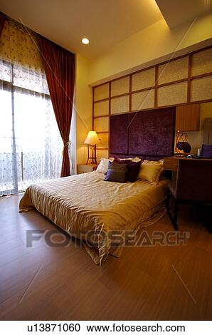 Stock Image - Modern bedroom with a French window, curtains pulled apart. Fotosearch