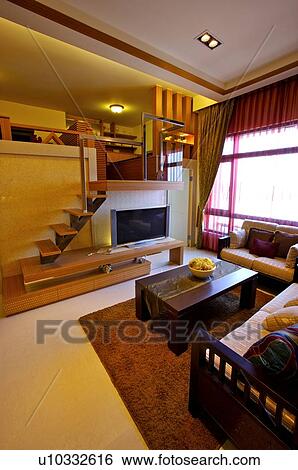 Stock Photograph - Modern living room with a television, and stairs leading to another room. Fotosearch