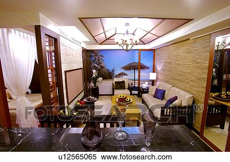 Stock Photography - Overview of a modern living room, lit by a chandelier, with a great view through the window. Fotosearch