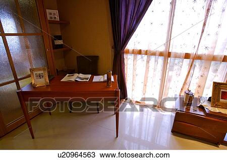 Wooden desk beside a French window, with a photo frame and books on it View Large Photo Image Stock Image - Wooden desk beside a French window, with a photo frame and books on it. Fotosearch