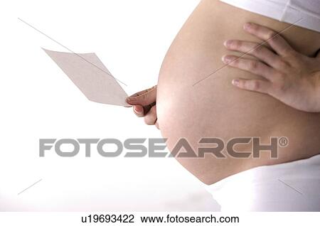 Pregnant woman holding a piece of paper, hand on hip, close-up View Large Photo Image Stock Image - Pregnant woman holding a piece of paper, hand on hip, close-up. Fotosearch