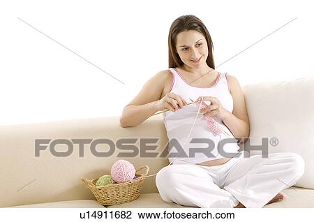 Pregnant woman knitting with balls of wool, sitting on sofa, smiling View Large Photo Image Stock Image - Pregnant woman knitting with balls of wool, sitting on sofa, smiling. Fotosearch