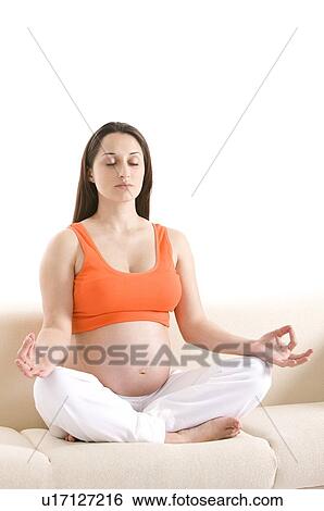 Pregnant young woman in lotus position, sitting on sofa Stock Photograph  u17127216  Fotosearch