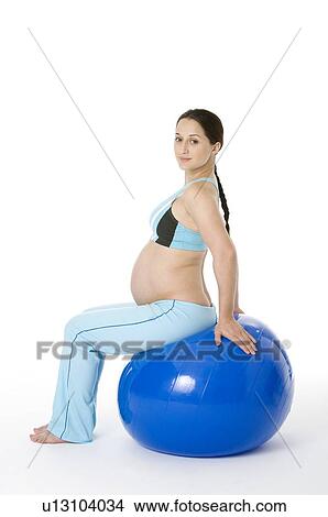 Picture - Pregnant young woman sitting on a fitness ball. Fotosearch