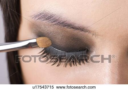 A young woman applying eye shadow View Large Photo Image Stock Photography - A young woman applying eye shadow. Fotosearch