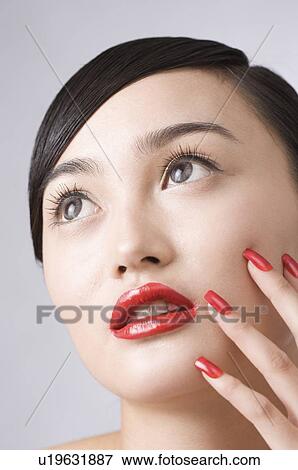Close-up of a young woman's face with red lips View Large Photo Image Stock Photo - Close-up of a young woman's face with red lips. Fotosearch