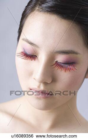 Close-up of a young woman's face with red fake eyelashes View Large Photo Image Stock Photograph - Close-up of a young woman's face with red fake eyelashes. Fotosearch