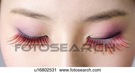 Close up of young woman wearing long false red eyelashes View Large Photo Image Stock Image - Close up of young woman wearing long false red eyelashes. Fotosearch