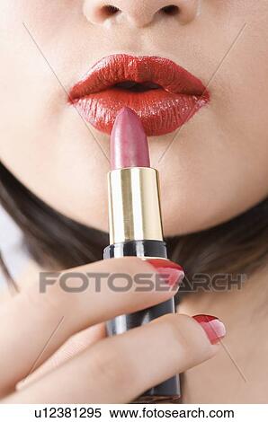 Stock Photography - Woman applying lipstick. Fotosearch