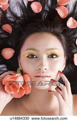 Woman with a rose in her left hand amongst rose petals View Large Photo Image Stock Image - Woman with a rose in her left hand amongst rose petals. Fotosearch
