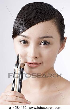 Young woman holding make-up brushes View Large Photo Image Stock Image - Young woman holding make-up brushes. Fotosearch