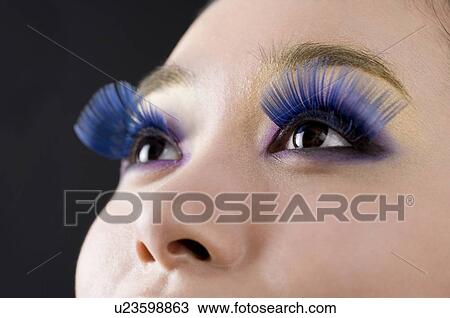 Young woman wearing false blue eyelashes View Large Photo Image Stock Image - Young woman wearing false blue eyelashes. Fotosearch