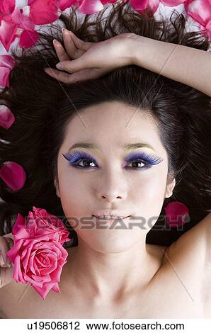 Young woman wearing false eyelash lying around petals View Large Photo Image Stock Image - Young woman wearing false eyelash lying around petals. Fotosearch