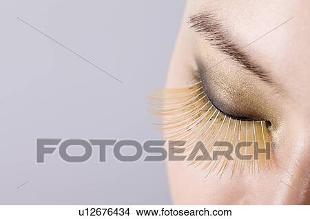 Young woman wearing long false eyelash View Large Photo Image Picture - Young woman wearing long false eyelash. Fotosearch