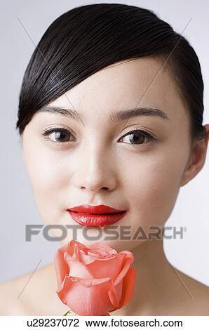 Young woman with a rose under her chin View Large Photo Image Stock Image - Young woman with a rose under her chin. Fotosearch