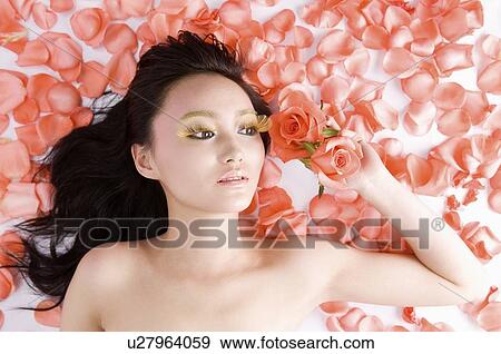 Young women amongst rose petals View Large Photo Image Stock Photo - Young women amongst rose petals. Fotosearch