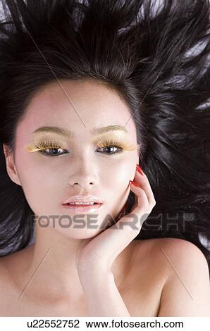 Young women with face between black hair, portrait, close-up View Large Photo Image Stock Image - Young women with face between black hair, portrait, close-up. Fotosearch