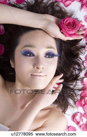 Young women with false purple eyelashes lying beside petals View Large Photo Image Stock Photography - Young women with false purple eyelashes lying beside petals. Fotosearch