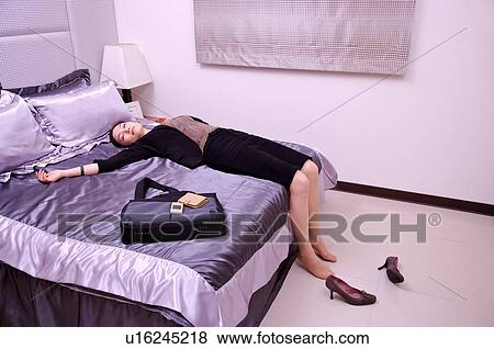 Young woman lying on bed sleeping View Large Photo Image Stock Photo - Young woman lying on bed sleeping. Fotosearch