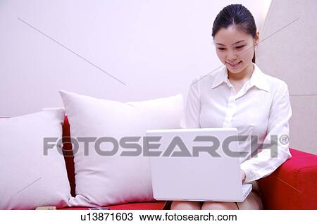 Young woman working on laptop at home View Large Photo Image Stock Image - Young woman working on laptop at home. Fotosearch