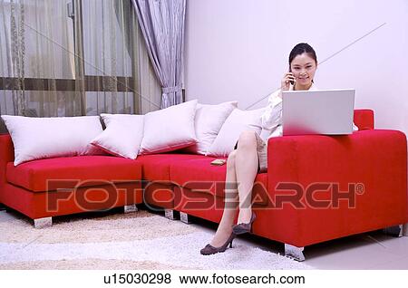 Stock Photo - Young woman working on laptop at home. Fotosearch