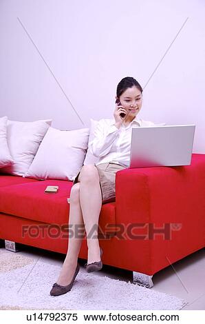 Stock Photography - Young woman working on laptop at home. Fotosearch