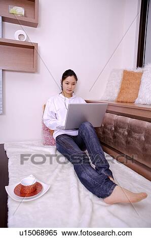 Stock Photography - Young woman working on laptop at home. Fotosearch