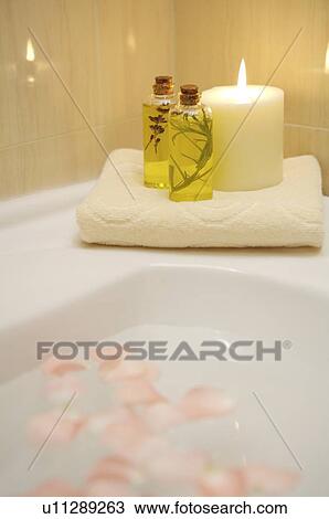 Aromatherapy oil, burning candle and folded towel on the edge of bathtub View Large Photo Image Stock Image - Aromatherapy oil, burning candle and folded towel on the edge of bathtub. Fotosearch