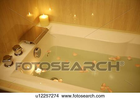 Picture - Bathtub filled with water and rose petals. Fotosearch
