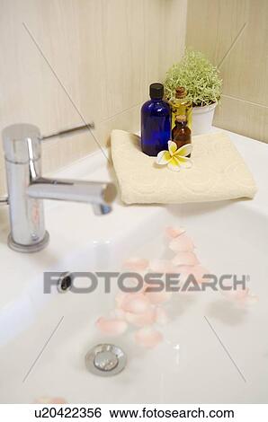 Bathtub full of water and rose petals with spa treatment on the edge View Large Photo Image Stock Photograph - Bathtub full of water and rose petals with spa treatment on the edge. Fotosearch