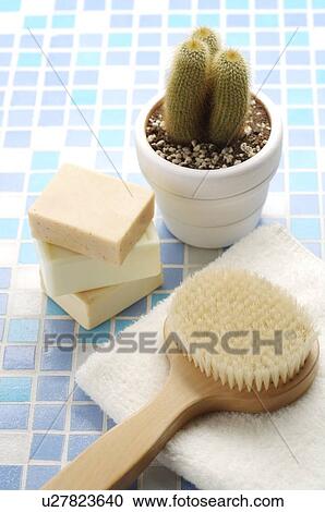 Stock Image - Brush on the towel beside soaps and pot culture. Fotosearch