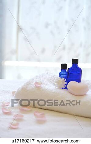 Stock Photo - Folded towel with aromatherapy oil and heart shape on top. Fotosearch