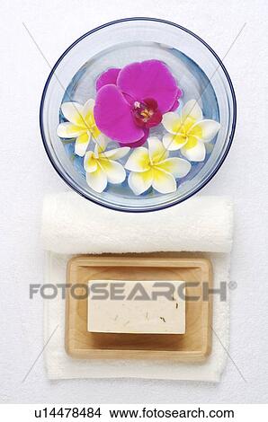 Picture - Soap, rolled towel and frangipani in a bowl. Fotosearch