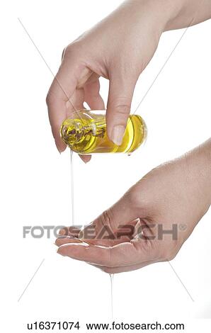 Woman pouring aromatherapy oil on her another hand View Large Photo Image Picture - Woman pouring aromatherapy oil on her another hand. Fotosearch