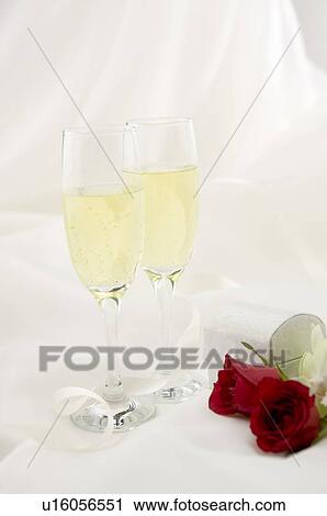 Stock Image - Champagne and red rose on fabric. Fotosearch