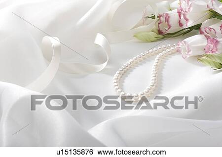 Stock Photograph - Pearl necklace and roses on fabric. Fotosearch
