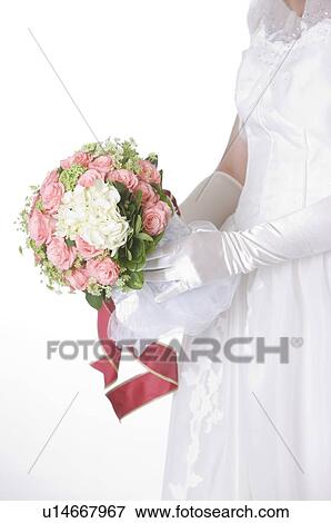Stock Photo - Side view of bride holding wedding bouquet. Fotosearch