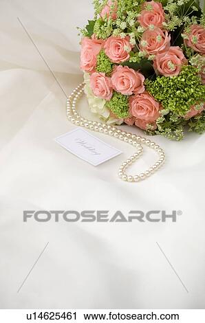 Wedding bouquet, pearl necklace and wedding name tag on fabric View Large Photo Image Stock Image - Wedding bouquet, pearl necklace and wedding name tag on fabric. Fotosearch