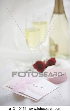 Stock Image - Wedding invitation, box and champagne on fabric. Fotosearch