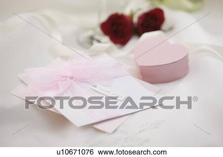 Stock Photograph - Wedding invitation, jewelry box and rose on fabric. Fotosearch