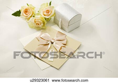 Stock Image - Wedding invitation, roses and box on fabric. Fotosearch