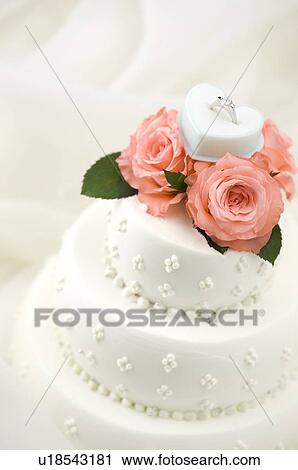 Wedding ring and prink roses on wedding cake View Large Photo Image Stock Image - Wedding ring and prink roses on wedding cake. Fotosearch
