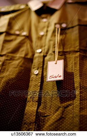 A red and white 'Sale' sign hanging from the button of a shirt, selective focus View Large Photo Image Stock Photo - A red and white 'Sale' sign hanging from the button of a shirt, selective focus. Fotosearch