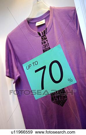 Stock Photo - Blue discount sign in front of a purple T-shirt. Fotosearch