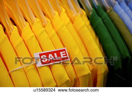 Picture - Close-up of a row of T-shirts, on sale. Fotosearch
