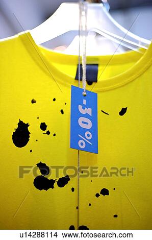 Picture - Discount sign in front of a yellow T-shirt, close-up. Fotosearch