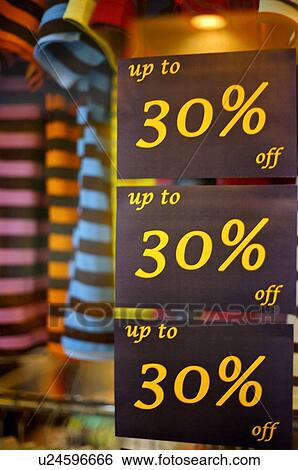 Stock Photograph - Discount signs on the window of a clothing store, close-up. Fotosearch