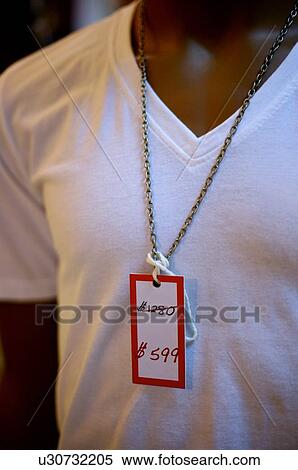 Stock Photography - Discounted price sign hanging on necklace of a male mannequin. Fotosearch