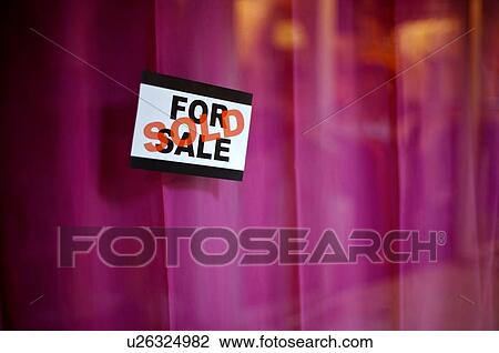 Stock Image - For Sale' and 'Sold' signs in a window, against a purple background. Fotosearch