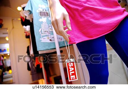 Red and white 'Sale' sign hanging from a mannequin's hand in a clothing store View Large Photo Image Stock Image - Red and white 'Sale' sign hanging from a mannequin's hand in a clothing store. Fotosearch